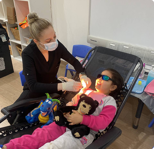 A girl receiving a routine dentist-checkup-girl-teeth, as the dentist carefully examines her teeth under in a modern clinic.